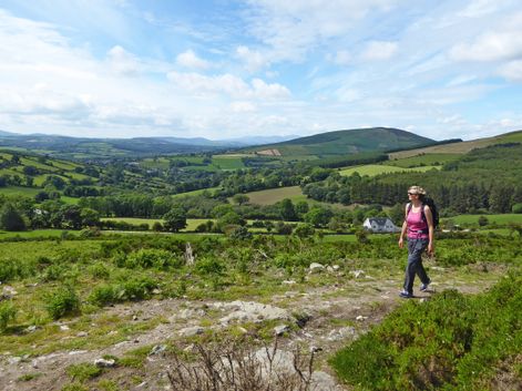 Wanderin bestaunt die waunderbar grüne Landschaft Irlands