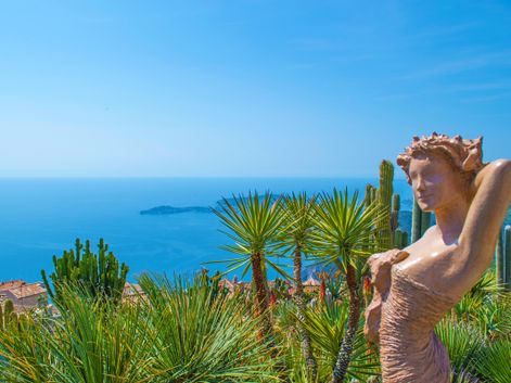 Weitblicke von einer Frauenstatue auf die Palmen, Bergdörfer und das Meer genießen