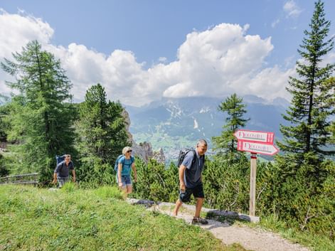 Hikers along the signpost in the Dolomites