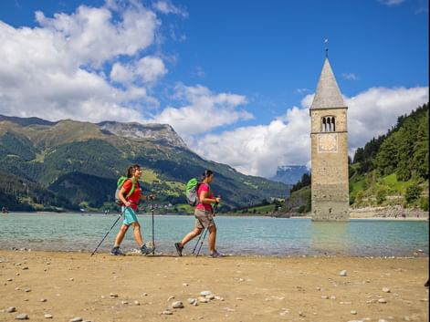 Hikers on the shore of lake Resia