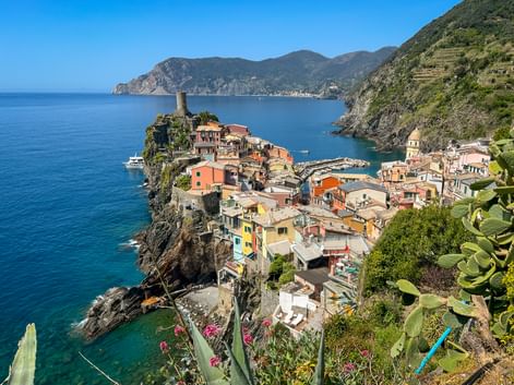 Vernazza village with colorful houses on rocky cliffs overlooking the Mediterranean Sea, with a small harbor and historic tower in Cinque Terre.