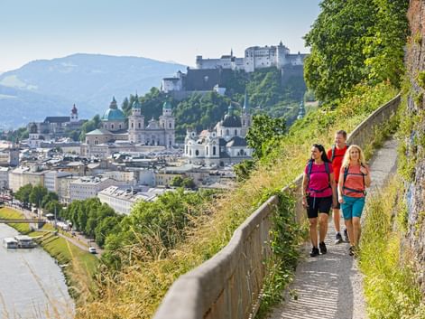 Hikers on the Mönchsberg with Salzburg's old town in the background