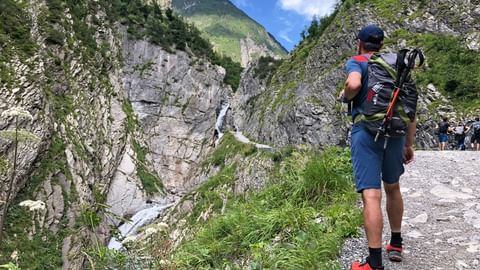 A hiker enjoys the view of Sims Waterfall in the Lech Valley