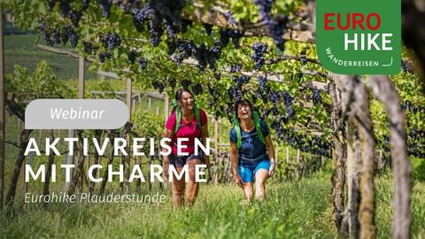 Zwei Wanderinnen mit Rucksäcken gehen zwischen Weinreben. Eurohike-Logo und Text 'Aktivreisen mit Charme' sichtbar.