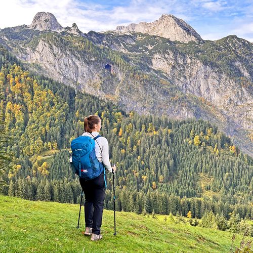 Hiker in front of an autumnal mountain panorama
