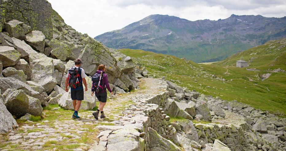 Hiking couple on a mule track built of stones in the mountains