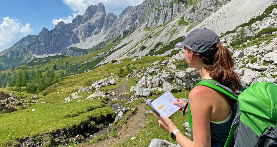 Hiker with travel documents looking towards Bischofsmütze