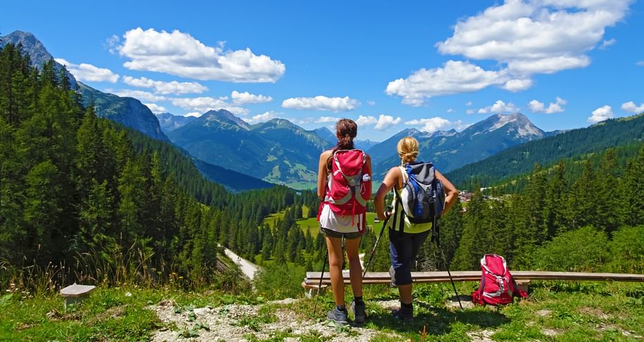 Zwei Wanderinnen vor atemberaubendem Bergpanorama