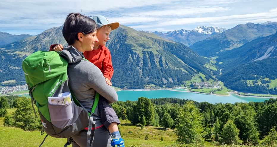 Hikers with a view of Lake Reschen in Italy