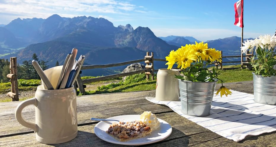Pflaumenkuchen am Tisch auf der Alm am Gosaukamm mit Bergpanorama
