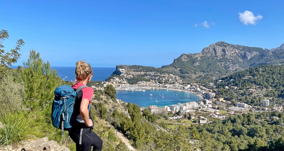 Hiker in front of the panoramic view of Port de Soller