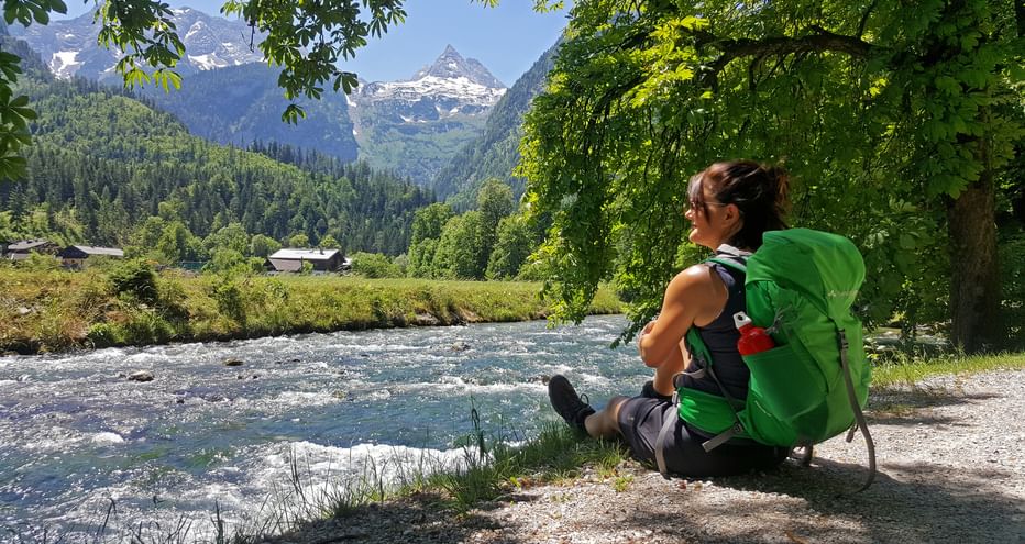 Hiker sitting by the stream with a view of the Loferer Steinberge mountains