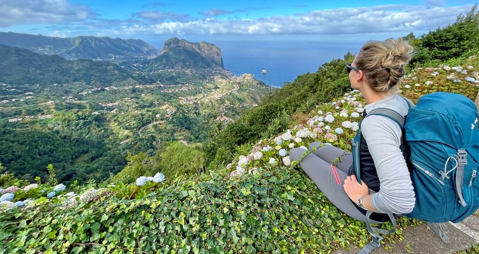 Wanderin genießt den Blick auf die Küstenlandschaft vom Aussichtspunkt Miradouro da Portela auf Madeira