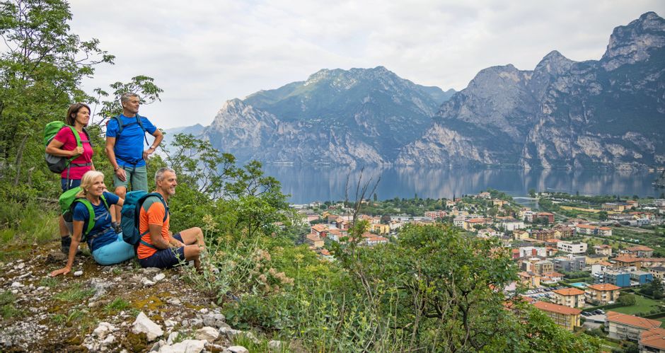 Hiking group enjoys the panoramic view of Torbole and the surrounding mountains on Lake Garda