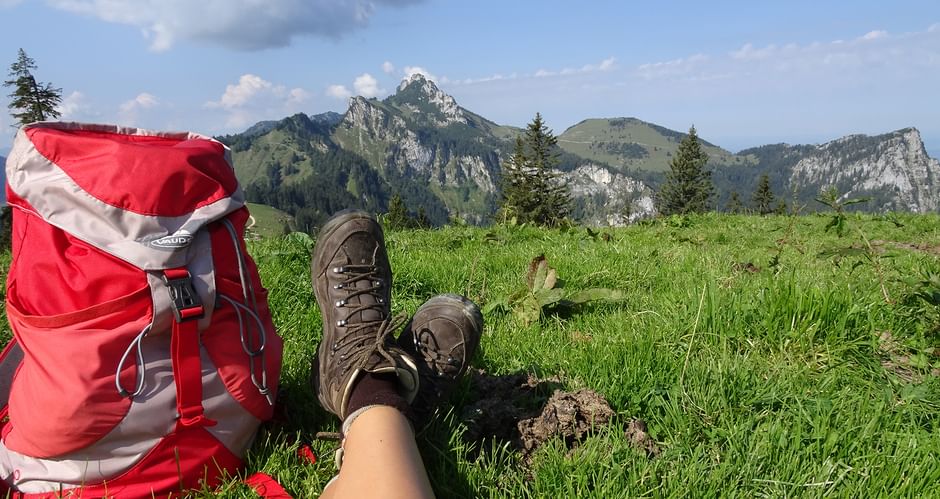 Wanderschuhe und Wanderrucksack vor Bergkulisse