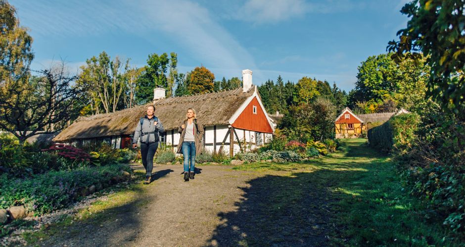 Wanderinnen bei Ferienhäusern auf einer Etappe von Alunbruket nach Verkasjön in Österlenleden