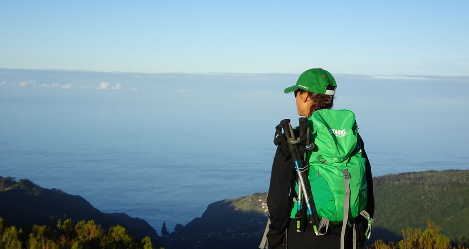 Wanderin auf Gipfel mit Blick aufs Meer und umliegende Berge auf Madeira