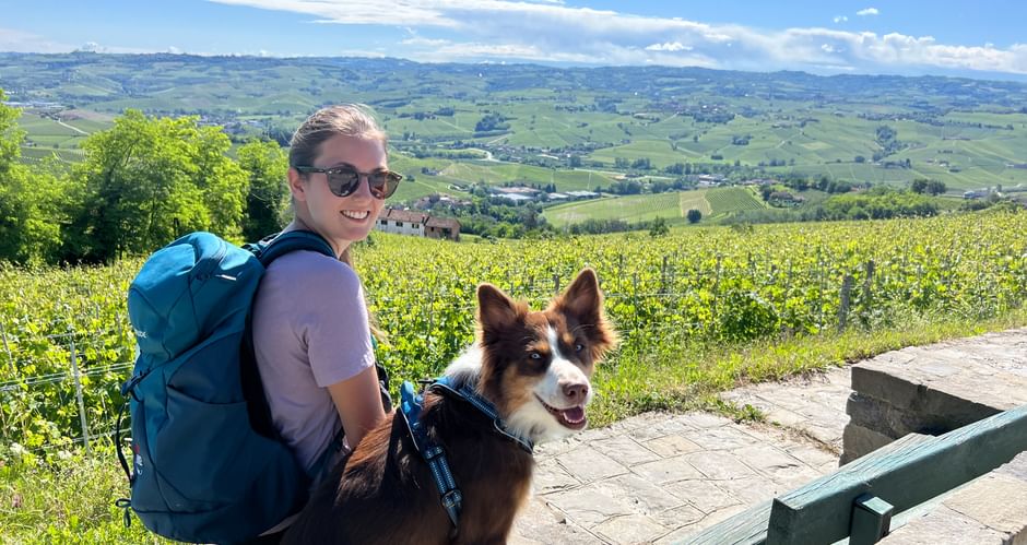 Wanderer und Hund mit Blick auf die Weinlandschaft des Piemonts