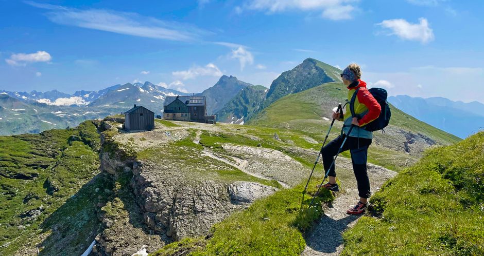 Hikers with a view of Hagener Hütte in the Gastein Valley