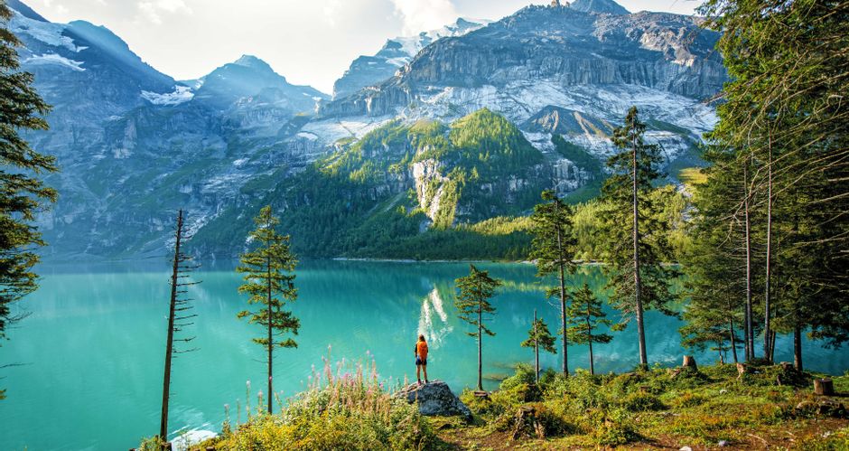 Wanderer am türkisblauen Bergsee Oeschinensee mit Bergpanorama im Hintergrund